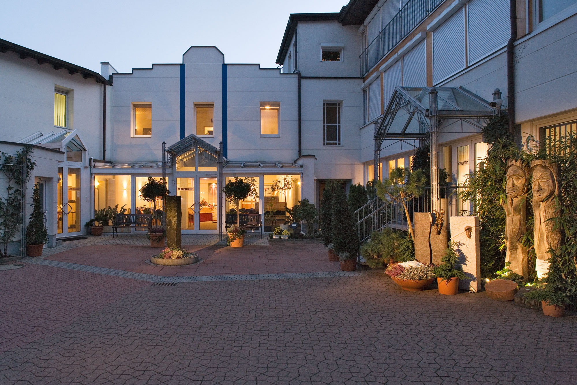 Nachtaufnahme vom Innenhof der Trauerhilfe Stier in Karlsruhe. Die Gebäude sind stimmungsvoll beleuchtet.